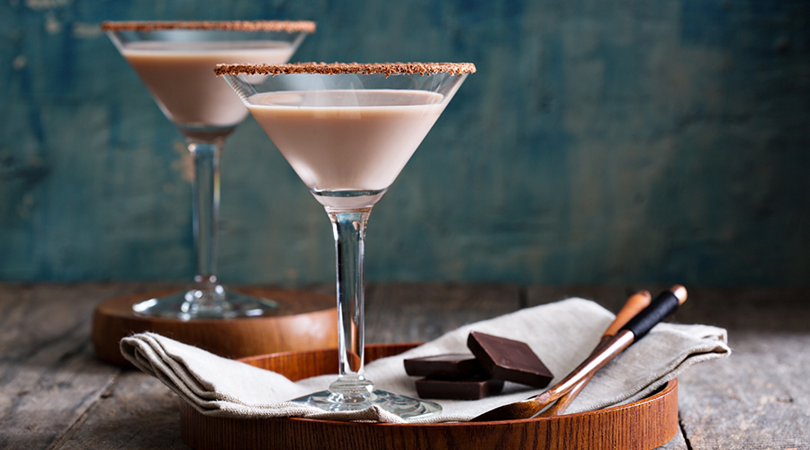 two chocolate margarita cocktails in martini glasses with chocolate on the rim