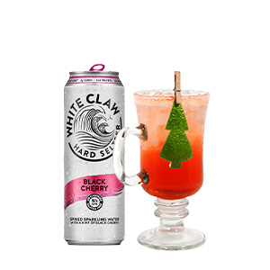 A can of black cherry White Claw next to a cocktail with a Christmas tree on it