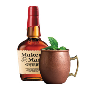 A bottle of Makers Mark Bourbon next to a cocktail in a copper mug